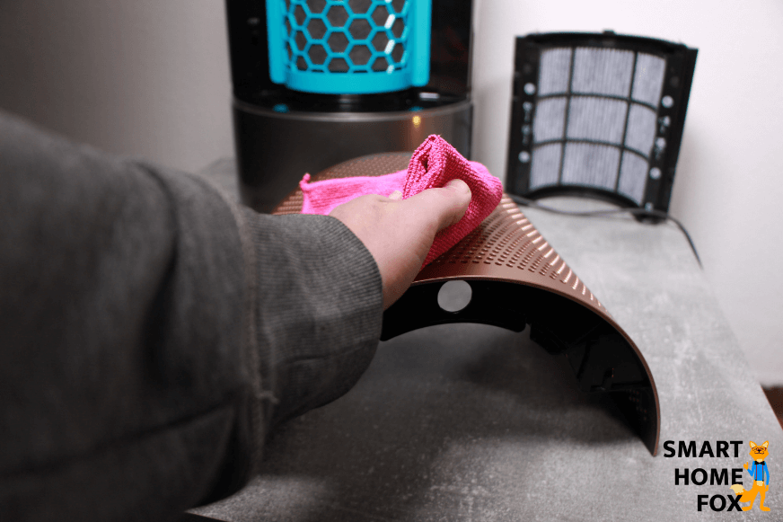 Das Luftgitter vom Dyson Purifier Humidify+Cool Formaldehyde PH04 Luftreiniger liegt auf dem Tisch und wird mit einem weichen Tuch abgestaubt.